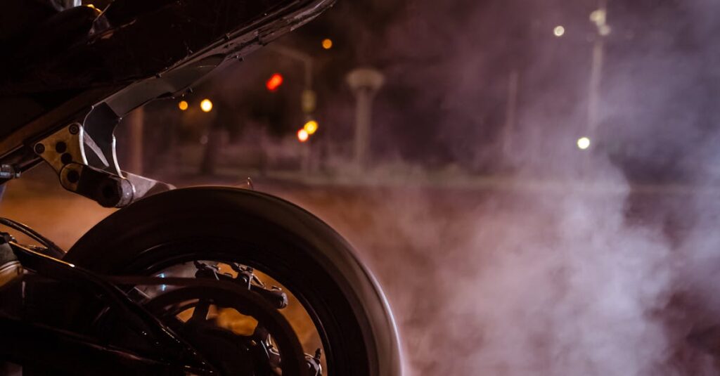 Dynamic shot of a motorcycle burnout with smoke on a night road, showcasing speed and adrenaline.