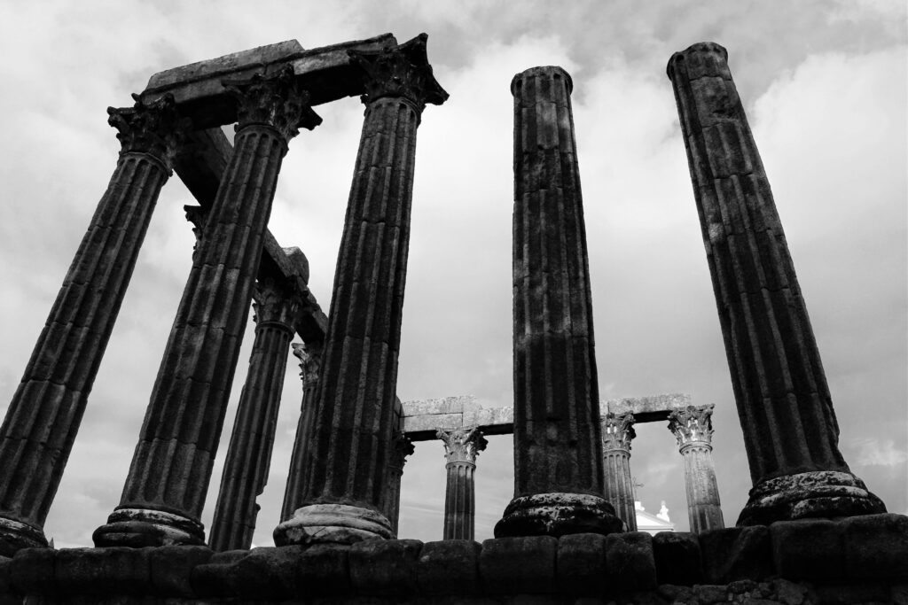 Black and white photo of ancient Roman columns in Évora, Portugal, showcasing timeless architecture.